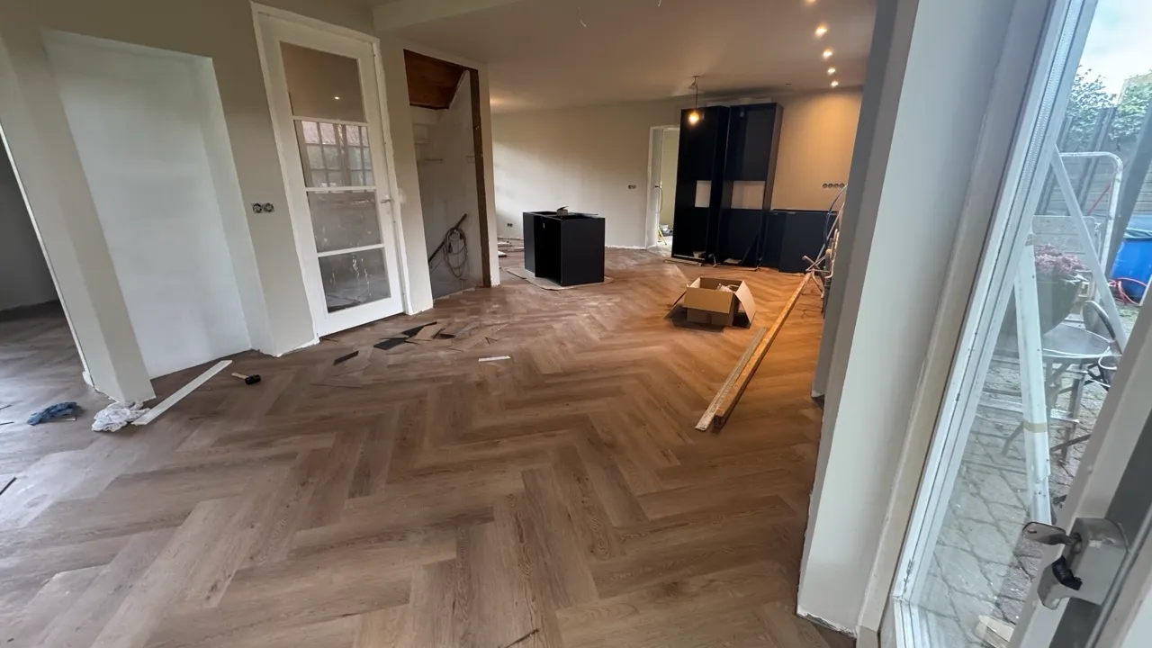 Een woning tijdens de renovatie, met visgraatvloer en keuken